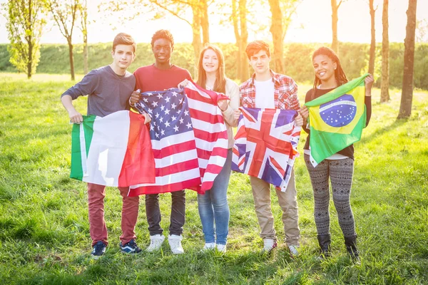 Amigos adolescentes sosteniendo banderas de diferentes países — Foto de Stock