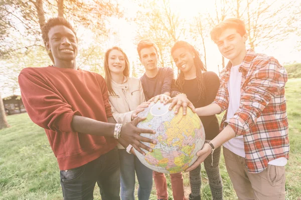 Groupe d'adolescents détenant la carte mondiale Globe — Photo