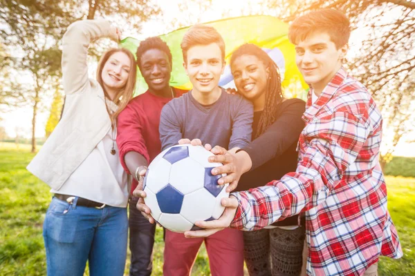 Amigos adolescentes sosteniendo bandera brasileña y balón de fútbol — Foto de Stock