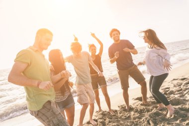 çok ırklı bir grup arkadaşıyla birlikte plajda parti