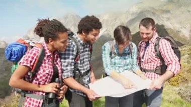 Hikers Looking at Map on top of Mountain