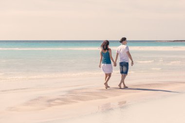 Karayip kumsalda yürüyen genç bir çift