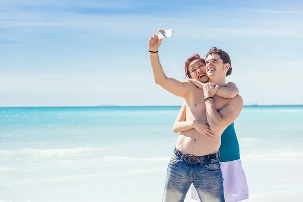 Pareja joven tomando selfie en la playa — Foto de Stock