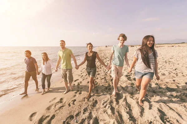 Multiraciale groep vrienden wandelen op het strand — Stockfoto