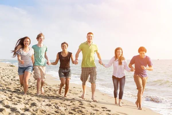 Multirassische Gruppe von Freunden zu Fuß am Strand — Stockfoto