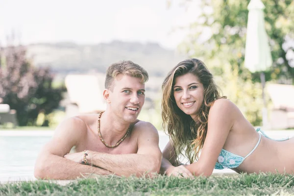 Belle jeune couple à côté de la piscine — Photo