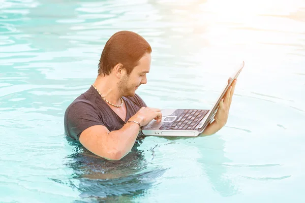 Man med datorn i poolen — Stockfoto