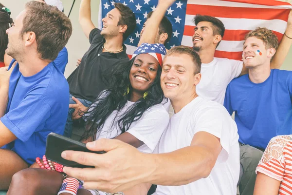 Amerikanske supportere som tar Selfie på stadion – stockfoto