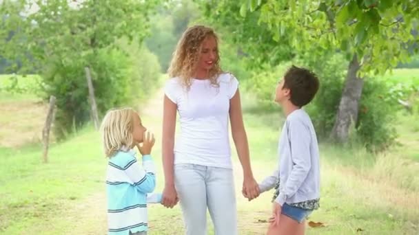 Schöne junge Frau mit zwei Kindern draußen — Stockvideo