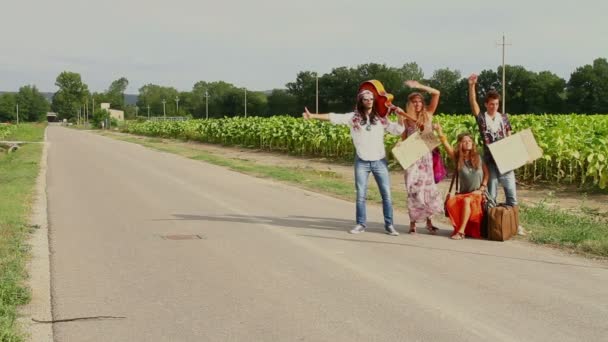 Hippie groep liften op een weg van het platteland — Stockvideo