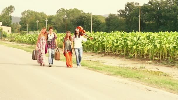 Ομάδα hippie περπατώντας σε ένα δρόμο εξοχή — Αρχείο Βίντεο