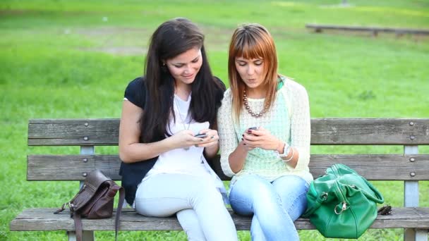 Dos mujeres jóvenes con teléfono móvil — Vídeos de Stock