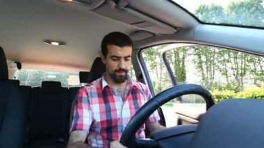 Genç adam araba kullanıyor.