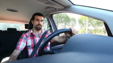 Genç adam araba kullanıyor.