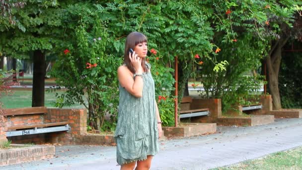 Mulher bonita com telefone móvel no parque — Vídeo de Stock