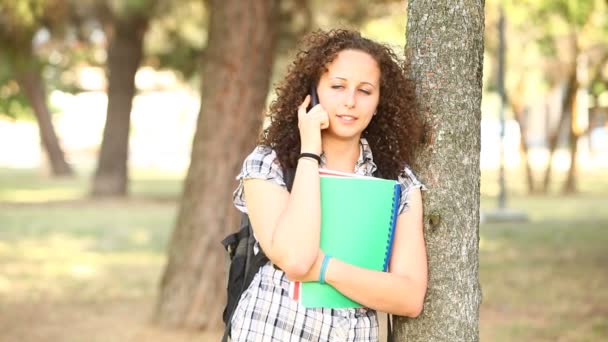 Студент с мобильным телефоном в парке — стоковое видео