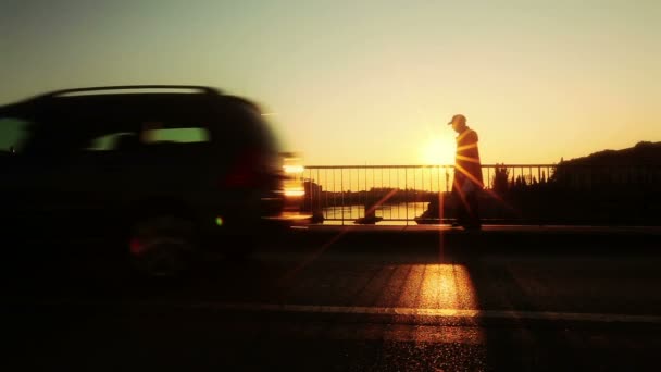 Silhouette von Autos, die bei Sonnenuntergang über die Brücke fahren — Stockvideo