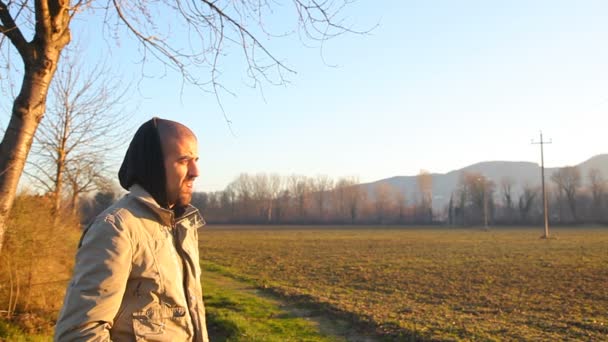 男人站在秋日的田野 — 图库视频影像