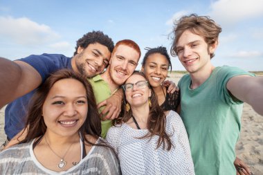 Çok ırklı grup arkadaşıyla kumsalda Selfie alarak
