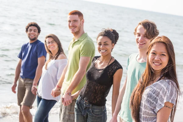 Çok ırklı bir grup arkadaşıyla kumsalda yürüyen — Stok fotoğraf