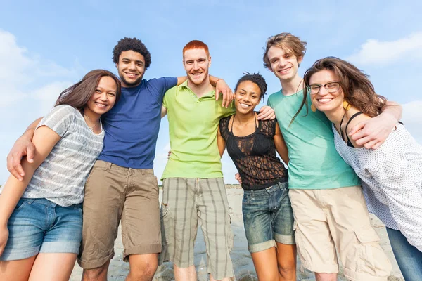 Multiraciale groep vrienden op strand — Stockfoto