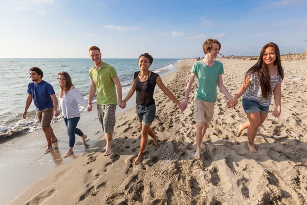 Multirassische Gruppe von Freunden zu Fuß am Strand — Stockfoto