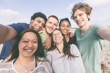 Çok ırklı grup arkadaşıyla kumsalda Selfie alarak