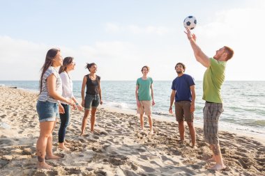 Kumsalda Voleybol oynayan arkadaşlar çok ırklı grup