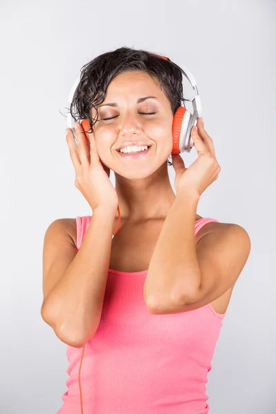 Mujer joven escuchando música con auriculares — Foto de Stock