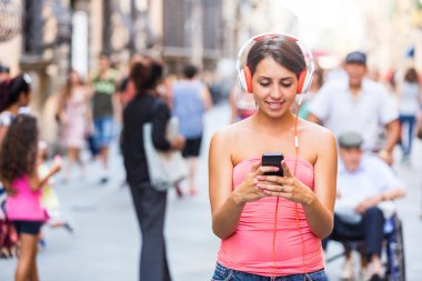 kulaklıklar ve kalabalık str, cep telefonu ile güzel kız