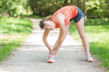 güzel bir genç kadın germe egzersizleri yapıyor