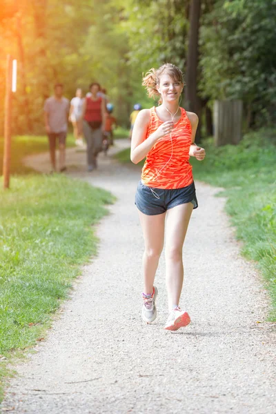 Piękna młoda kobieta joggingu w parku — Zdjęcie stockowe