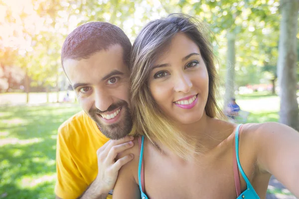 Casal jovem levando selfie no parque — Fotografia de Stock