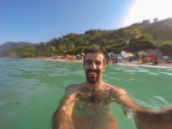 Jonge man nemen selfie in het water — Stockfoto