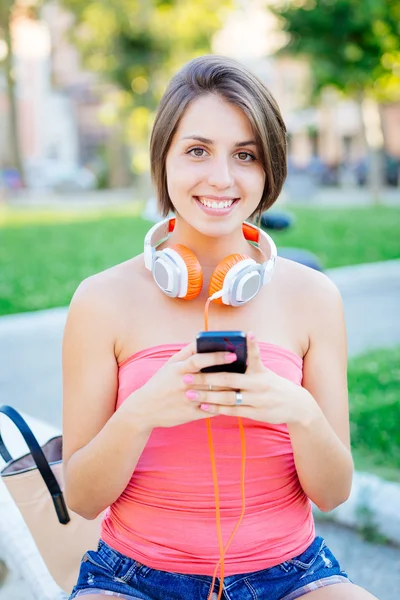 Menina bonita com telefone móvel no parque — Fotografia de Stock