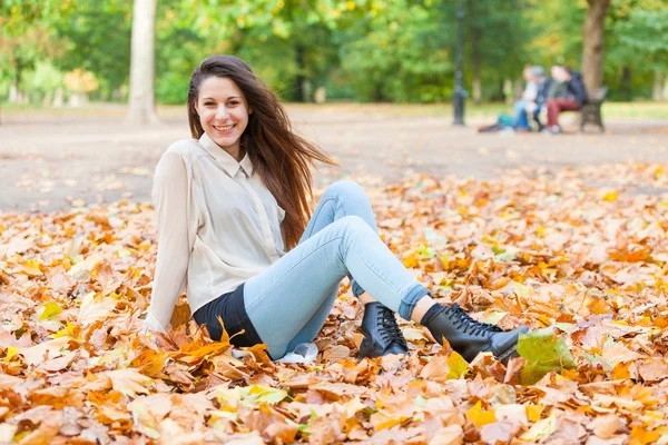 Giovane donna gioiosa al parco in autunno — Foto Stock