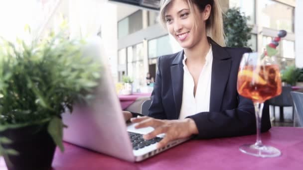 Mujer de negocios usando el ordenador portátil durante un descanso — Vídeos de Stock