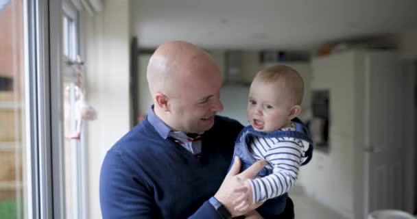 Jeune père jouant avec son nouveau-né garçon dans le salon — Video