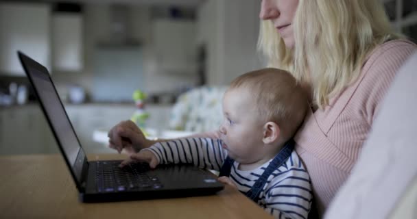 Jovem mãe trabalhando em casa e brincando com seu bebê recém-nascido no l — Vídeo de Stock