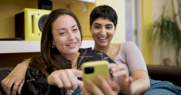 Feliz pareja lesbiana sonriendo y relajándose en el sofá — Vídeos de Stock