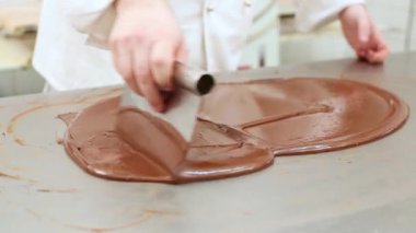 Restoranın mutfağında çikolatayı sertleştiren pasta şefi.
