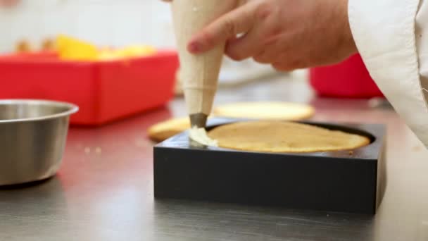 Cukiernik w pracy w kuchni restauracji ozdobiony słodkim ciastem z bitą śmietaną — Wideo stockowe