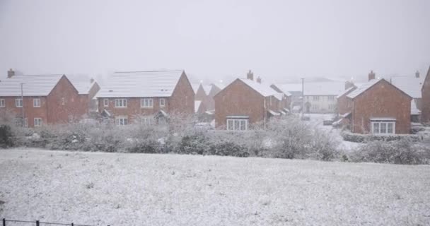 Neve che cade in una fredda giornata invernale in Inghilterra in un tipico villaggio — Video Stock