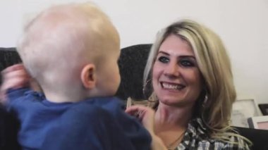 Anne evdeki kanepede oğluyla oynuyor.