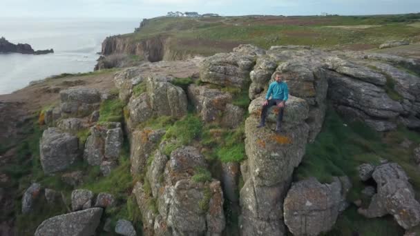 Man op een klif in Cornwall genietend van het uitzicht — Stockvideo