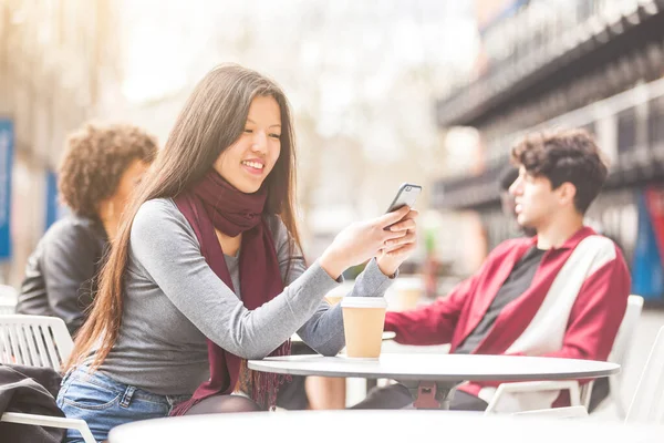 快乐的中国女人在咖啡馆里用智能手机 时尚的年轻女人坐在户外餐桌边 在伦敦喝咖啡 生活方式 科技和交流理念 — 图库照片