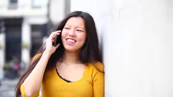 Mujer china feliz hablando por teléfono y sonriendo — Vídeo de stock