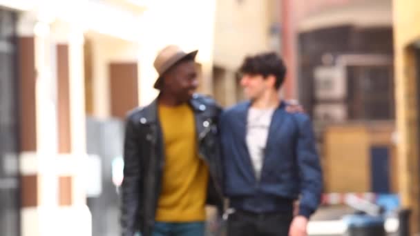 Multiracial gay pareja caminando abrazado en londres, hablando y teniendo divertido tog — Vídeo de stock