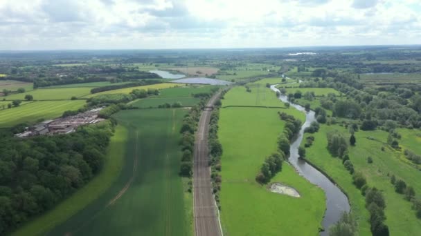 Vista aérea del campo verde y el ferrocarril que lo atraviesa — Vídeo de stock