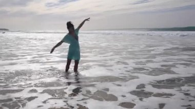 Fuerteventura 'da deniz kenarında tek başına yürüyüp su sıçratan güzel bir kadın.